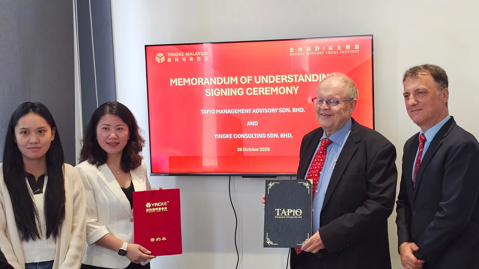 Representatives of TAPiO and Yingke Malaysia holding their signed MoU folders